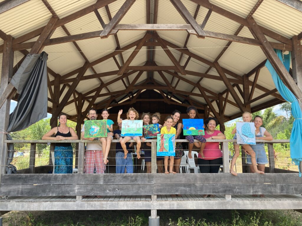 un groupe de parents et enfants montrent leur peinture en duo après un super atelier créatif